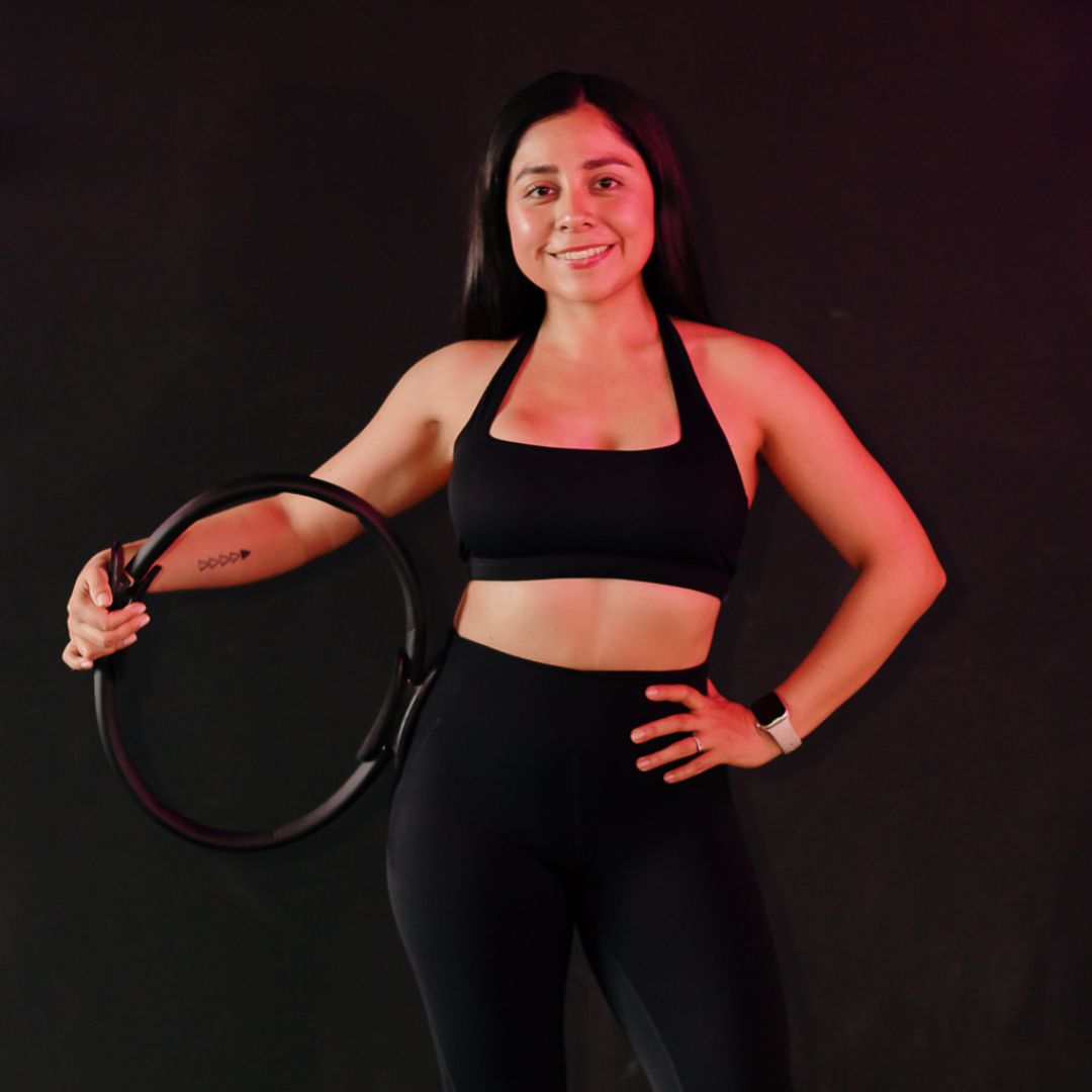Head Coach Olga de MOVE Barre Studio Xalapa posando con un aro de pilates antes de clase.